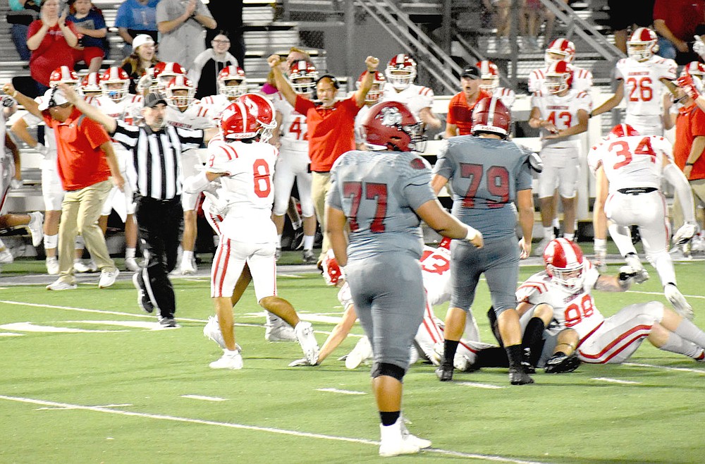MARK HUMPHREY ENTERPRISE-LEADER/Farmington players and coaches rejoice after Sam Wells (No. 8) tackled a running back short of a first causing a turnover on downs. The play was aided greatly by the defensive line surge of Braden Bullington (No. 99) and teammates up front. The Cardinals beat Class 7A Springdale 20-19 on Friday.