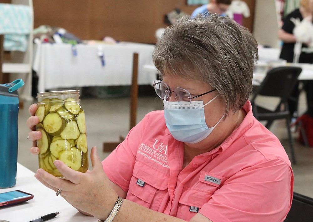 Judge Jean Ince looks over a jar of pickles during the Creative Arts judging at the Garland County Fair Monday. - Photo by Richard Rasmussen of The Sentinel-Record