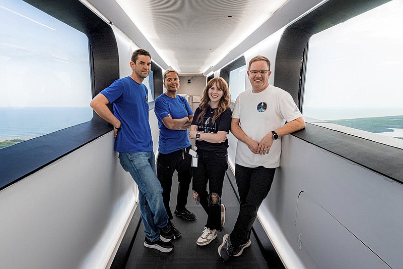 In this July 28, 2021 photo provided by John Kraus, from left, Jared Isaacman, Sian Proctor, Hayley Arceneaux and Chris Sembroski stand in the crew access arm at Launch Complex 39A at Kennedy Space Center in Florida. They will use this arm to board the Falcon 9 rocket on launch day. (John Kraus/Inspiration4 via AP)