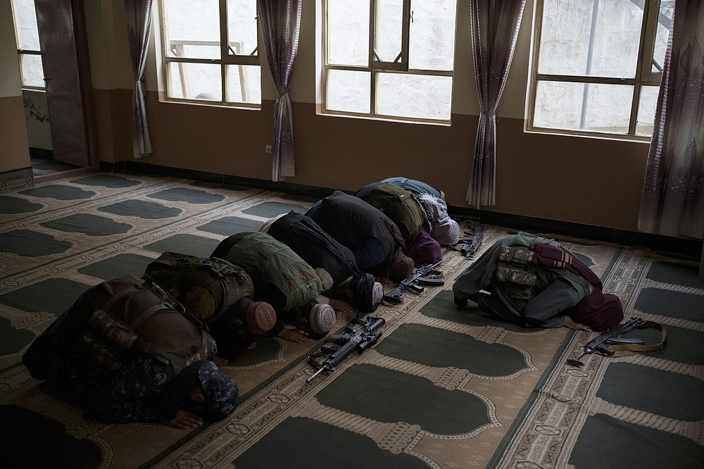 Taliban members lay their weapons down as they pray inside a mosque in Kabul, Afghanistan, Sunday, Sept. 12, 2021. (AP Photo/Felipe Dana)