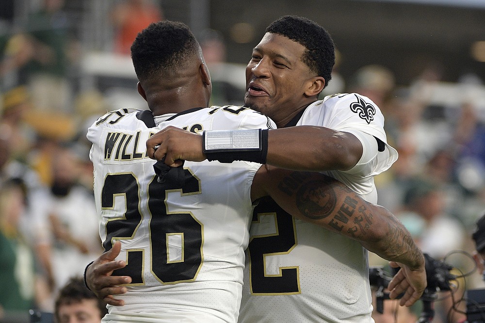 New Orleans Saints cornerback P.J. Williams (26) and quarterback Jameis  Winston (2) hug after an NFL