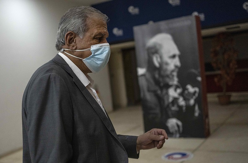 Mitchell Joseph Valdes Sosa, the director of the Cuban Neurosciences Center, walks past a photo of Fidel Castro before a press conference about symptoms reported by U.S. and Canadian diplomats  in 2016 and 2017, commonly referred to as the &#x201c;Havana Syndrome,&quot; in Havana, Cuba, Monday, Sept. 13, 2021. (AP Photo/Ramon Espinosa)