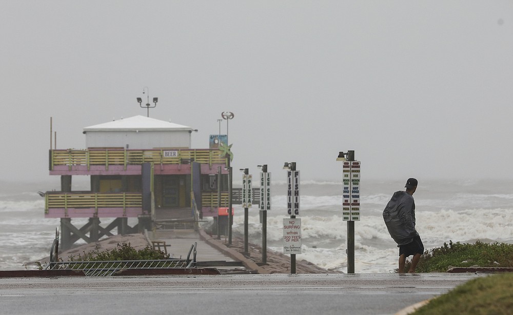 A man walks down Seawall Boulevard near 61st Street on Tuesday, Sept. 14, 2021, in Galveston, Texas. Hurricane Nicholas made landfall early in the morning along the coast. (Jon Shapley/Houston Chronicle via AP)