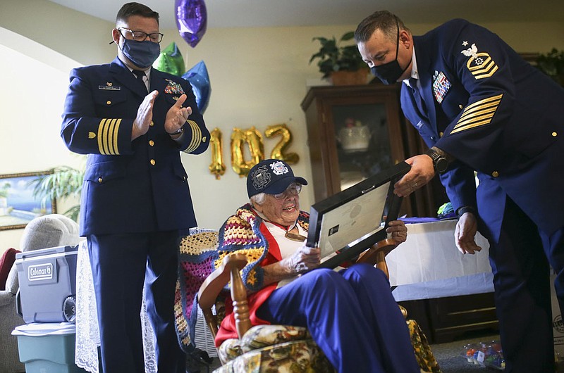 U.S. Coast Guard Sector Commander Ryan Rhodes (left) applauded as U.S. Coast Guard Senior Chief Jameson Hannaman (right) presents The Hope Award citation to Lois Bouton (center), Thursday, September 16, 2021 at the Innisfree Assisted Living in Rogers. 102 year old Lois Bouton is known as &quot;The Coast Guard Lady&quot;. She received the Spirit of Hope Medal from the Department of Defense and Pentagon Thursday at her retirement community home. Check out nwaonline.com/210919Daily/ for today's photo gallery. 
(NWA Democrat-Gazette/Charlie Kaijo)