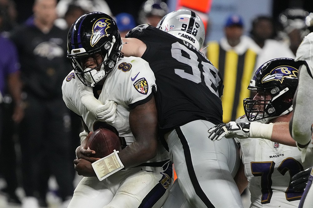 Las Vegas Raiders defensive end Maxx Crosby (98) tackles Baltimore Ravens quarterback Lamar Jackson (8) during the second half of an NFL football game, Monday, Sept. 13, 2021, in Las Vegas. (AP Photo/Rick Scuteri)