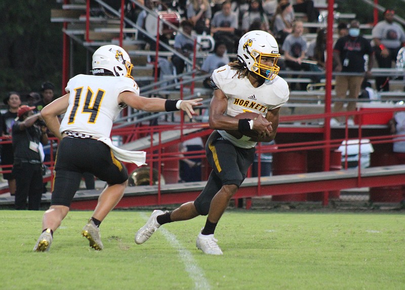 Hornets running back Tobias Hicks takes the handoff from quarterback Caleb Johnson in the game against Fordyce