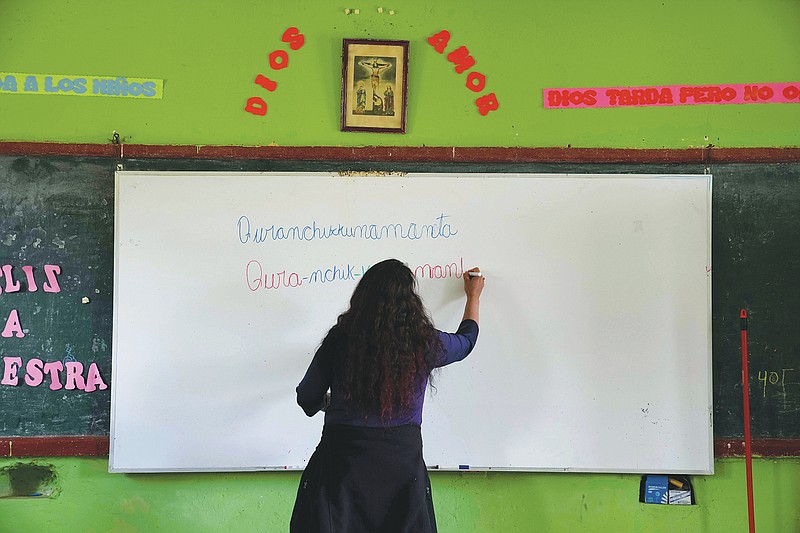 Teacher Carmen Cazorla writes in the Quechua Indigenous language during a class on medicinal plants at a public primary school in Licapa, Peru, Wednesday, Sept. 1, 2021. &#x201c;For 500 years Spanish has been imposed in a way that reflects the racist and classist values of Peruvian society,&#x201d; said Cazorla, an anthropologist who also teaches Quechua at the Catholic University of Peru. (AP Photo/Martin Mejia)