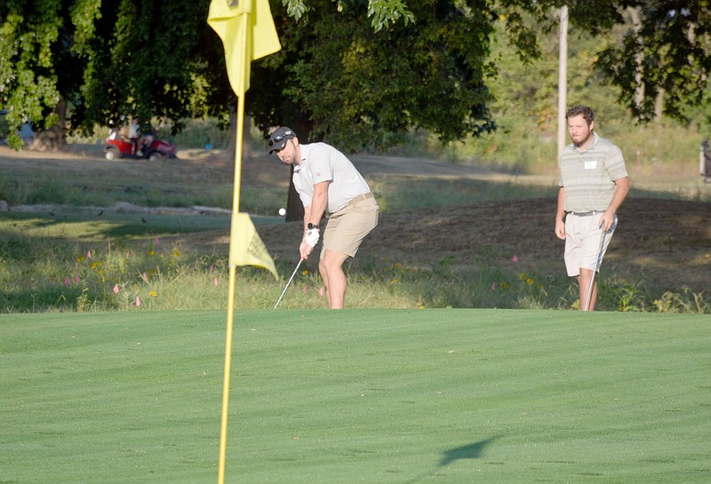 Marc Hayot/Siloam Sunday Trevor Gies (left), gets ready to shoot his golf ball into the Seventh Hole while Teammate Sam Greenleaf looks on at the Chamber Challenge. Gies and Greenleaf were one of the two-man teams from Cobb Vantress Inc. competing in the Siloam Springs Chamber of Commerce's annual golf tournament at The Course at Sager's Crossing.