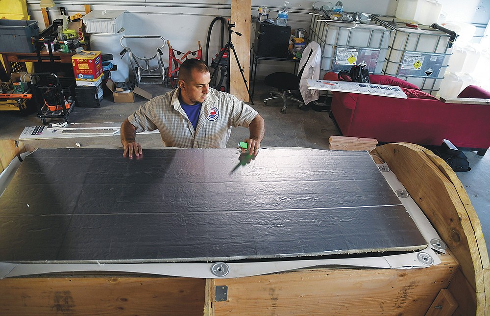 In this Wednesday, Aug. 11, 2021, photo, employee Chris Olachia works on a nearly completed human body composting vessel in Arvada, Colo. On Sept. 7, Colorado became the second state after Washington to allow human body composting, and Oregon will allow the practice beginning next July. The vessel will be packed with wood chips and straw and will be able to compost a body in six months. (AP Photo/Thomas Peipert)