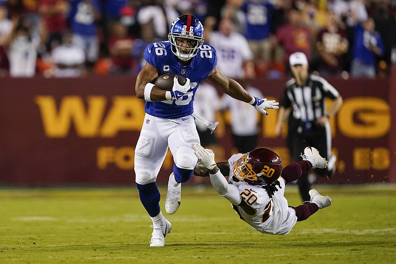 New York Giants running back Saquon Barkley (26) breaks away from Washington Football Team cornerback Bobby McCain (20) as he runs with the ball during the first half of Thursday's NFL game in Landover, Md. - Photo by Alex Brandon of The Associated Press