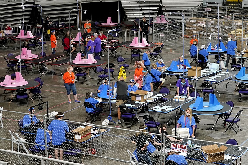 FILE - In this May 6, 2021 file photo, Maricopa County ballots cast in the 2020 general election are examined and recounted by contractors working for Florida-based company, Cyber Ninjas at Veterans Memorial Coliseum in Phoenix. An attorney representing the Republican-controlled Arizona Senate told a judge Thursday, Sept. 16, 2021, that the long-delayed review of 2020 election results in the state's most populous county will be released to the public next week. (AP Photo/Matt York, Pool, File)