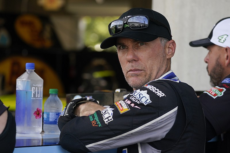 FILE - In this Saturday, Aug. 14, 2021, file photo, Kevin Harvick waits in his garage before practice for a NASCAR Cup Series auto race at Indianapolis Motor Speedway, in Indianapolis. Chase Elliott, according to Harvick, doesn't race very smart. In fact, moving forward in NASCAR's playoffs, Harvick plans to run all over the reigning Cup champion. Those were the angry words Harvick had for Elliott after the race at Bristol Motor Speedway, Saturday, Sept. 18, where a feud no one saw coming took center stage. (AP Photo/Darron Cummings, File)