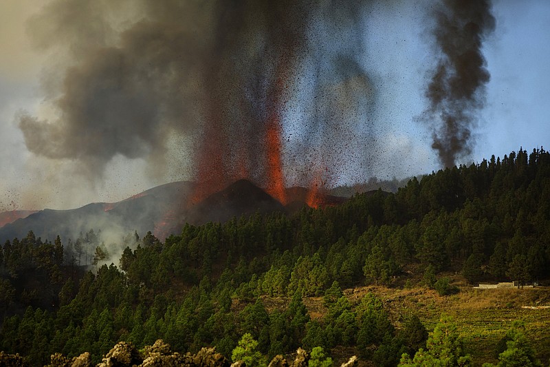 Lava flows from an eruption of a volcano at the island of La Palma in the Canaries, Spain, Sunday, Sept. 19, 2021. A volcano on Spain's Atlantic Ocean island of La Palma erupted Sunday after a weeklong buildup of seismic activity, prompting authorities to evacuate thousands as lava flows destroyed isolated houses and threatened to reach the coast. New eruptions continued into the night. (AP Photo/Jonathan Rodriguez)