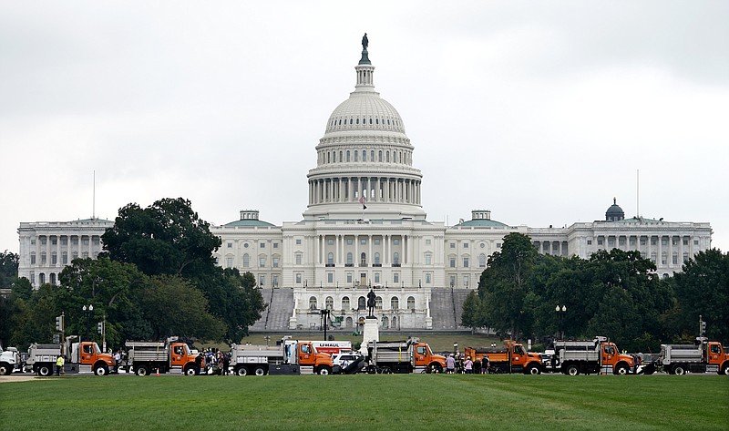 Dozens of dump trucks form a barrier as security measures are put into place before a rally near the U.S. Capitol in Washington, Saturday, Sept. 18, 2021. The rally was planned by allies of former President Donald Trump and aimed at supporting the so-called &quot;political prisoners&quot; of the Jan. 6 insurrection at the U.S. Capitol. (AP Photo/Gemunu Amarasinghe)