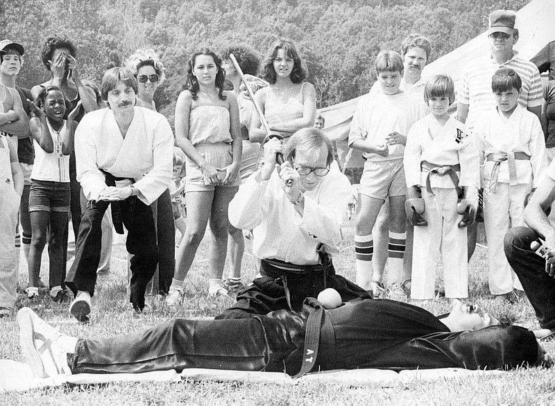 Al Taylor volunteers to let Bill Fulton slice an apple on his belly at Riverfest in a display of martial art prowess, according to the caption published with this photo in the May 24, 1981, Arkansas Democrat. Democrat photographer James Allison recorded that the men were part of a karate group from Northside YMCA. 
(Democrat-Gazette file photo)