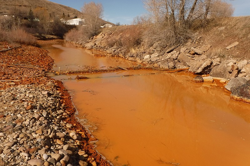 FILE - This March 7, 2016 photo provided by the Montana Department of Environmental Quality shows a polluted Belt Creek in Montana. The state plans to build a plant to treat acid mine drainage from an old coal mine that is polluting Belt Creek, sometimes causing it to turn a rusty color and harming the trout fishery. (Tom Henderson/Montana Department of Environmental Quality via AP)