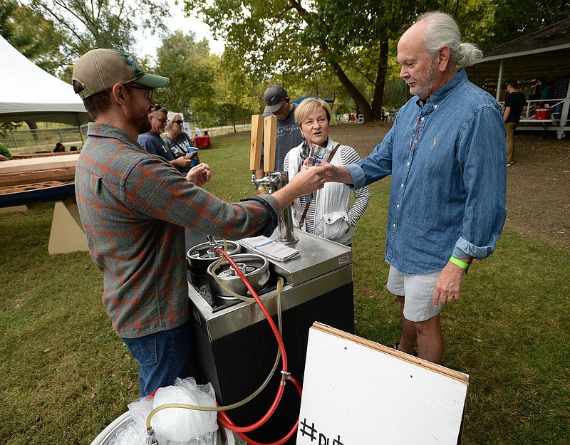 NWA Democrat-Gazette/ANDY SHUPE
Casey Letellier (from left), a brewer with the Ivory Bill Brewing Company in Siloam Springs, offers beers to taste Saturday, Oct. 19, 2019, to Raney and E.C. Forbes of Springdale during the Brews and Tunes Beer and Music Festival at Magnolia Gardens in Springdale. The festival is part of the three-day Downtown Springdale Alliance's third annual Ozarktober Fest and features music, craft beer and food trucks.