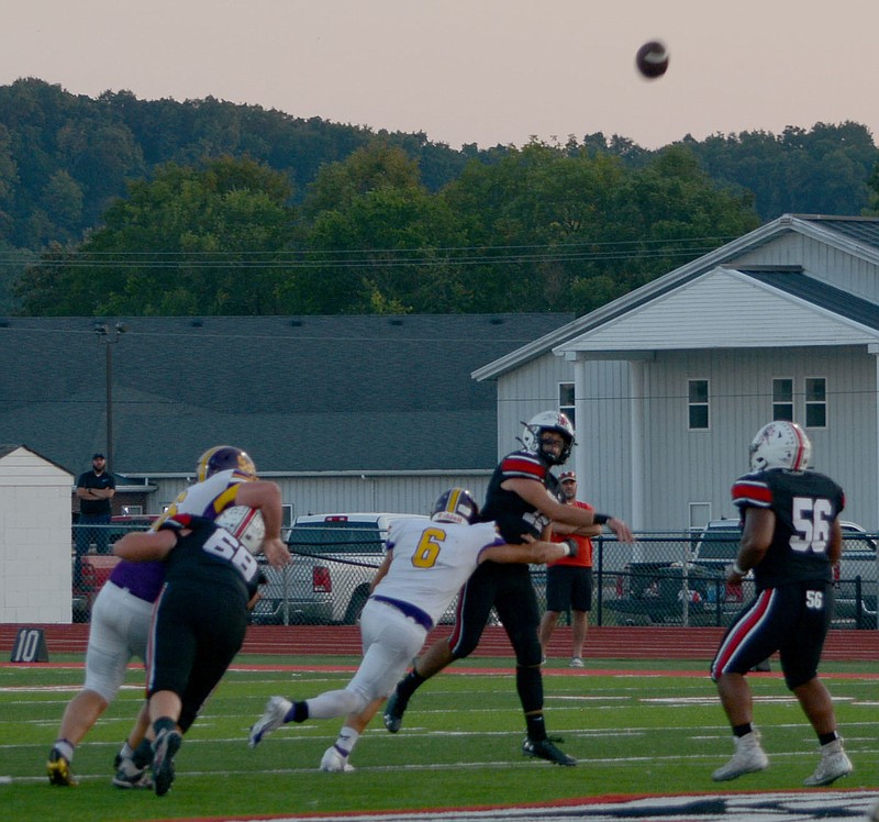 McDonald County quarterback Cole Martin fires a pass as Garrett Gricks (68) and Junior Eliam (56) block during the 31-14 victory over Monett.