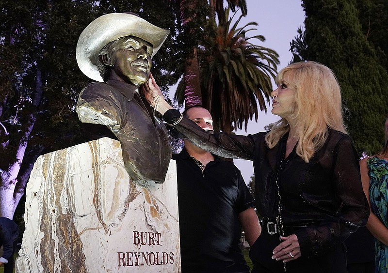 Actress Loni Anderson, the former wife of the late actor Burt Reynolds, touches a memorial sculpture of Reynolds during an unveiling ceremony at Hollywood Forever Cemetery, Monday, Sept. 20, 2021, in Los Angeles. Reynolds died in 2018 at the age of 82. (AP Photo/Chris Pizzello)