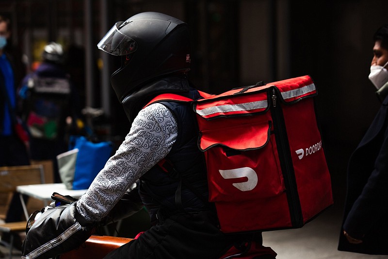 A demonstrator wearing a Doordash backpack in Times Square during a march for food delivery workers rights in New York, on April 21, 2021. MUST CREDIT: Bloomberg photo by Paul Frangipane.