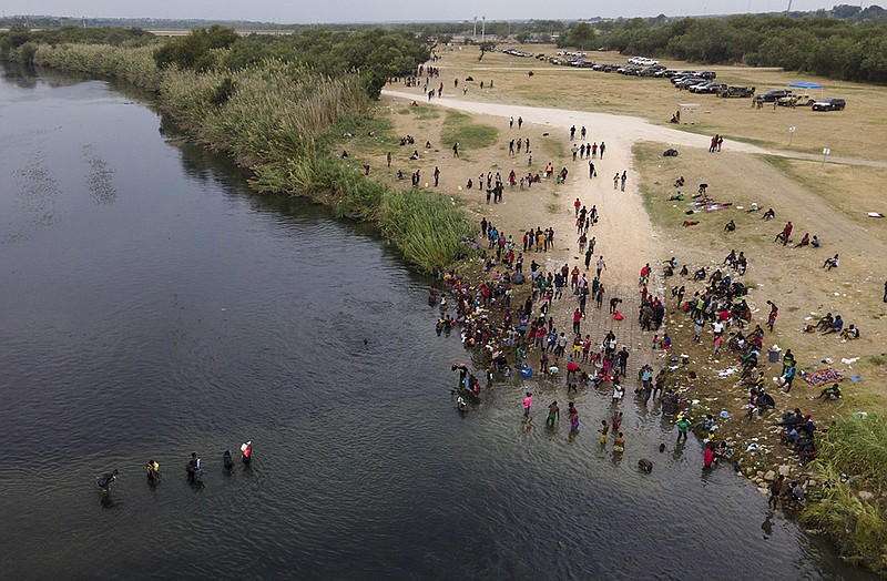 Migrants, many from Haiti, are seen wading between the U.S. and Mexico on the Rio Grande, Tuesday, Sept. 21, 2021, in Del Rio, Texas. The options remaining for thousands of Haitian migrants straddling the Mexico-Texas border are narrowing as the United States government ramps up to an expected six expulsion flights to Haiti and Mexico began busing some away from the border.(AP Photo/Julio Cortez)