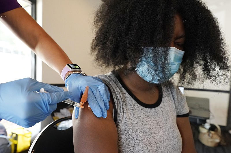 Jackson State University student Kendra Daye, right, reacts as Tameiki Lee, a nurse with the Jackson-Hinds Comprehensive Health Center, injects her with the Pfizer COVID-19 vaccine, in Jackson, Miss., across the street from the university, Tuesday, Sept. 21, 2021. The university in cooperation with Jackson-Hinds, provided vaccinations for community residents, faculty, staff and students, free of charge. The Board of Trustees of the Institutions of Higher Learning voted last week to ban public universities from requiring the COVID-19 vaccine for students, faculty and staff. (AP Photo/Rogelio V. Solis)