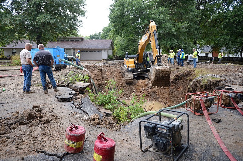 City of Fayetteville Water and Sewer Operations workers excavate Tuesday, Sept. 21, 2021, beneath Makeig Court after what was identified at the scene as a 36-inch water transmission line ruptured beneath the street Monday evening. The line supplies water from the Beaver Water District to the city of Fayetteville. Visit nwaonline.com/210922Daily/ for today's photo gallery.
(NWA Democrat-Gazette/Andy Shupe)