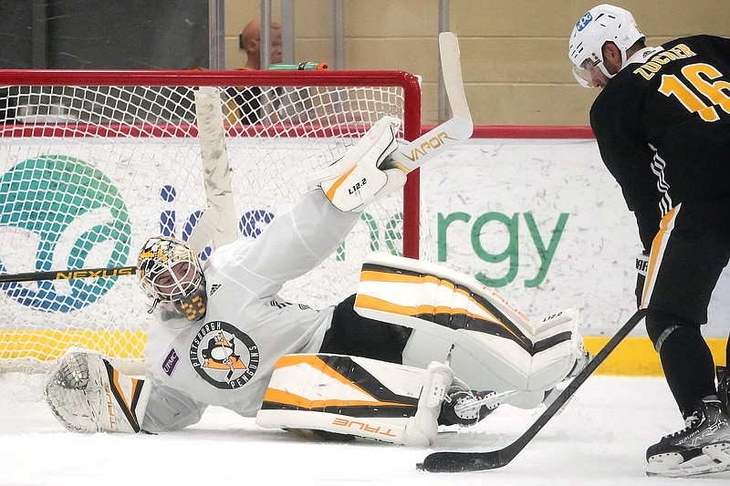 Pittsburgh Penguins goalie Alex D'Orio attempts to block a shot by Jason Zucker (16) during the team's first practice of the season in Cranberry, Pa. on Thursday. - Photo by Gene J. Puskar of The Associated Press