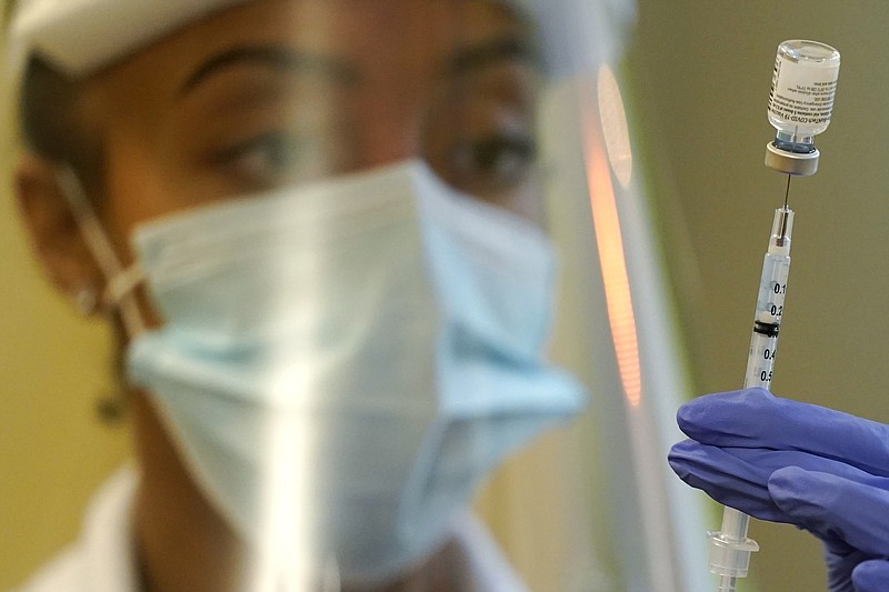 FILE - In this Jan. 8, 2021, file photo, a pharmacist prepares a syringe of the Pfizer vaccine for COVID-19, at Queen Anne Healthcare, a skilled nursing and rehabilitation facility in Seattle. The U.S. vaccination drive against COVID-19 stood on the verge of a major new phase as government advisers Thursday, Sept. 23, recommended booster doses of Pfizer's vaccine for millions of older or otherwise vulnerable Americans &#x2014; despite doubts the extra shots will do much to slow the pandemic. (AP Photo/Ted S. Warren, File)