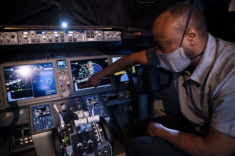 A Boeing employee demonstrates a touch screen control display in the cockpit of a Boeing Co. 737-9 aircraft at Ronald Reagan National Airport in Arlington, Va., on July 28, 2021. MUST CREDIT: Bloomberg photo by Al Drago