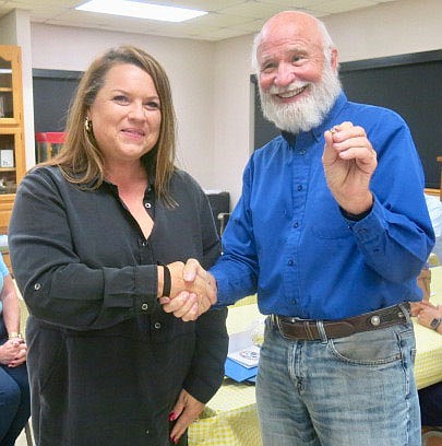 Westside Eagle Observer/SUSAN HOLLAND
Dan Yates, past district governor of MoArk District Kiwanis, sports a big smile as he shakes the hand of new Gravette Kiwanis Club member Allison Kurczek and displays her new member pin. The pin was awarded at the club's installation banquet Thursday evening, Sept. 23. Allison is the wife of club president Dennis Kurczek.