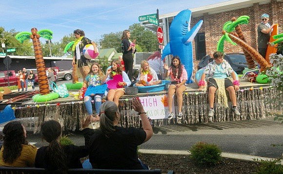 Westside Eagle Observer/SUSAN HOLLAND
The freshman class float in the Gravette High School homecoming parade featured a beach theme with some class members dressed in grass skirts and leis. Palm trees, beach balls and surfboards decorated the float with a friendly dolphin waving to the crowd.