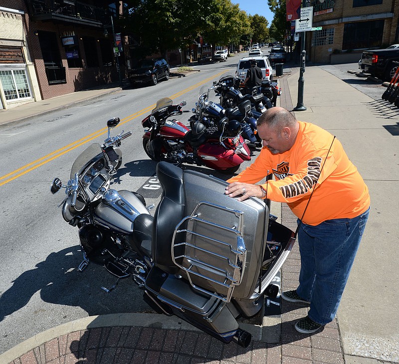 Scott Sargent of Rockwall, Texas, secures his motorcycle Saturday, Sept. 25, 2021, before venturing out onto Dickson Street in Fayetteville. The Bikes, Blues &amp; BBQ motorcycle rally did not happen this year after the University of Arkansas rescinded permits for the event planned at Baum-Walker Stadium. Visit nwaonline.com/210926Daily/ for today's photo gallery.
(NWA Democrat-Gazette/Andy Shupe)