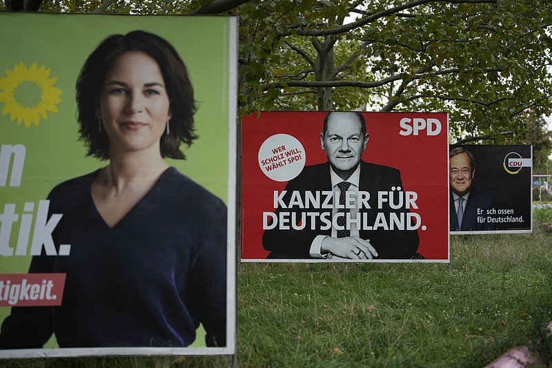 From left, election campaign billboards of candidates for chancellery, Annalena Baerbock of the Greens, Olaf Scholz of the Social Democrats and Armin Laschet of the Christian Union parties displayed in central Berlin, Saturday, Sept. 25, 2021. Germany?s closely fought election on Sunday will set the direction of the European Union?s most populous country after 16 years under Angela Merkel. The chancellor's party is scrambling to avoid defeat by its center-left rivals after a rollercoaster campaign. (AP Photo/Markus Schreiber)