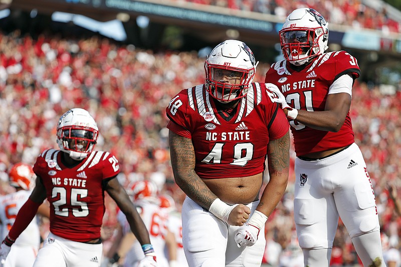 North Carolina State's Cory Durden (48) celebrates a sack with teammate Khalid Martin (21) and Shyheim Battle (25) during the first half of an NCAA college football game against Clemson in Raleigh, N.C., Saturday, Sept. 25, 2021. (AP Photo/Karl B DeBlaker)
