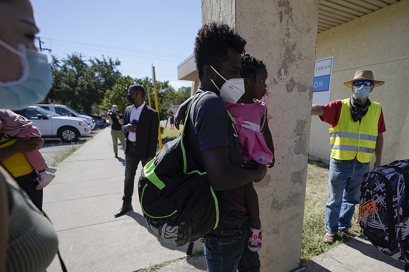 A man who gave his name only as Dave (right), from Toledo, Ohio, watches Friday as migrants are released from U.S. Customs and Border Protection custody in Del Rio, Texas.
 (AP/Julio Cortez)