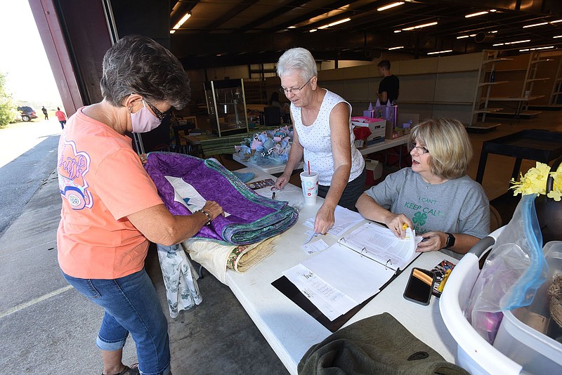 Cinda (cq) Wooldridge (left) of Pea Ridge enters her hand-made quilts on Saturday Sept. 25 2021 for judging at the Benton County Fair. Debe (cq) Greene (center) and Janice Shofner check in entries. 
(NWA Demorcrat/Gazette/Flip Putthoff)