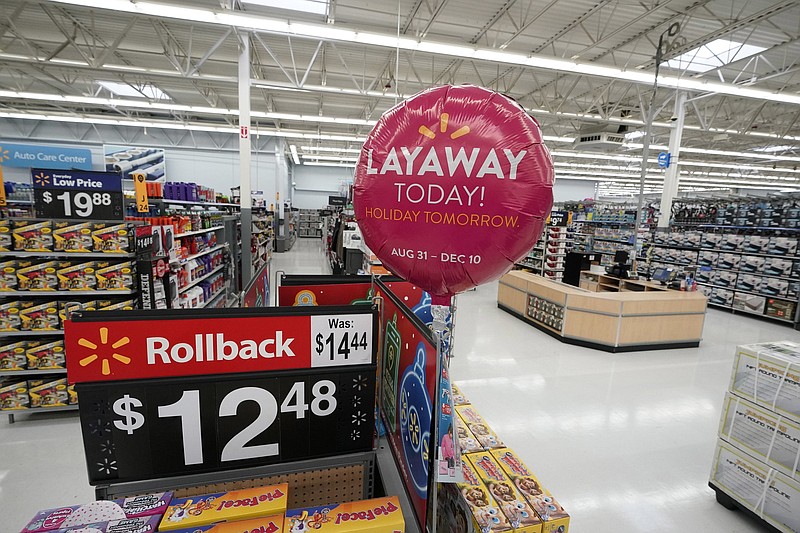 Signs promote sales and layaway inside a Walmart Supercenter Friday, Nov. 9, 2018, in Houston.