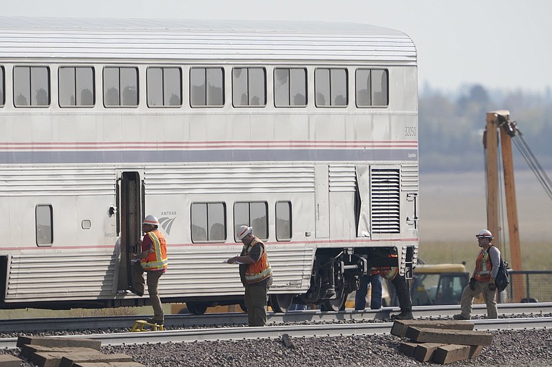 A Federal Railroad Administration worker steps into a passenger train car, Monday, Sept. 27, 2021, from an Amtrak train that derailed Saturday, near Joplin, Mont., killing three people and injuring others. Federal investigators are seeking the cause of the derailment. (AP Photo/Ted S. Warren)