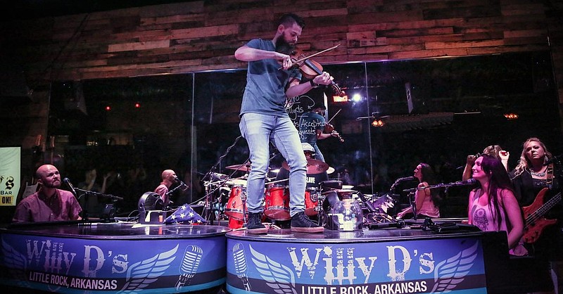 Willy D’s Dueling Pianos, featuring Susan Erwin Prowse (right) Matt Sammons (left), with Cliff Prowse shown playing fiddle atop the piano and Pamela Hopkins (far right), open up the music stage today at the Pulaski County Fair in North Little Rock. The performers normally entertain at Willy’s D’s club on President Clinton Avenue in Little Rock. (Special to the Democrat-Gazette)