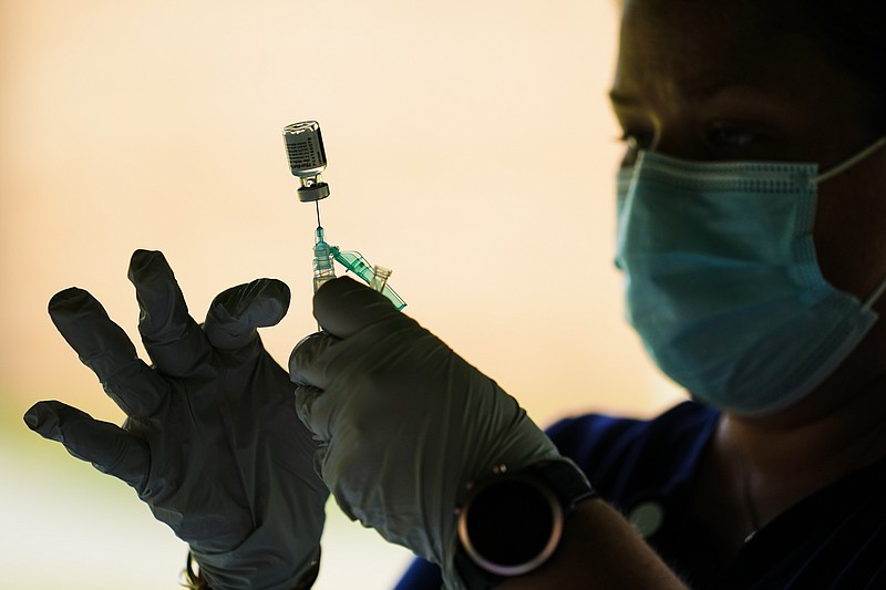 FILE - In this Sept. 14, 2021 file photo, a syringe is prepared with the Pfizer COVID-19 vaccine at a clinic at the Reading Area Community College in Reading, Pa. Businesses that have announced vaccine mandates say some workers who had been on the fence have since gotten inoculated against COVID-19. But many holdouts remain &#x2014; a likely sign of what is to come once a federal mandate goes into effect. (AP Photo/Matt Rourke, File)