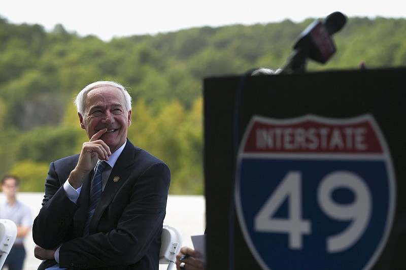 Gov. Asa Hutchinson smiles as he listens to Missouri Gov. Mike Parson speak (not pictured), Thursday, September 30, 2021 along the new Interstate 49 Bella Vista Bypass near Hiwasse. Arkansas Gov. Asa Hutchinson and Missouri Gov. Mike Parson joined highway officials from both states, highway commissioners, legislators and members of the public at the Arkansas-Missouri border to celebrate with a ribbon cutting. The newly constructed highway will open to the public Friday. Check out nwaonline.com/211001Daily/ for today's photo gallery. 
(NWA Democrat-Gazette/Charlie Kaijo)
