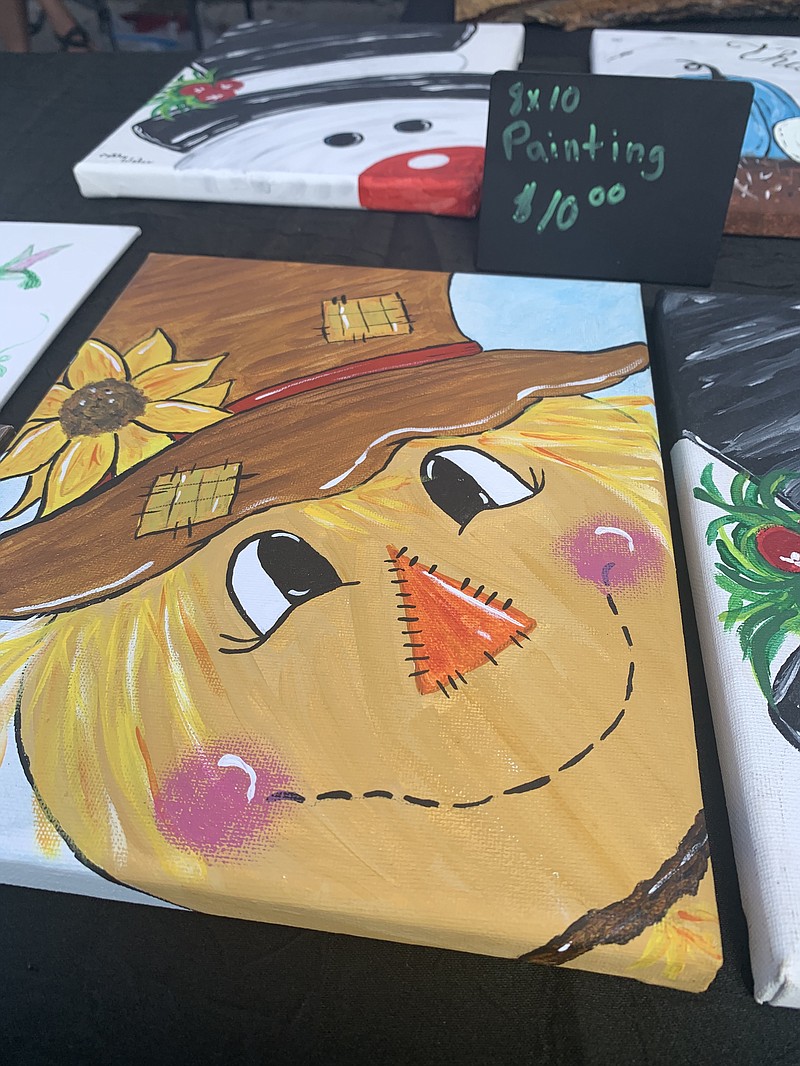 SALLY CARROLL/SPECIAL TO MCDONALD COUNTY PRESS Cathy Wales enjoys working with several art mediums, including acrylic painting. A scarecrow and a snowman are part of the art she displayed at Mountain Happenings at Sims Corner Farmers Market.