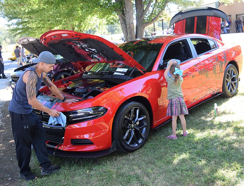 Westside Eagle Observer/MIKE ECKELS

While Josh Collins (left) works on cleaning the headlights on his custom Dodge Charger, his daughter Amelia works on polishing the mirror. The Collins and their muscle car were part of the 2021 Veterans Park Car Show in Decatur Sept. 25. All proceeds from the show goes to the Shoes 4 Kids program that provides a par of shoes for each student of the Decatur School District.