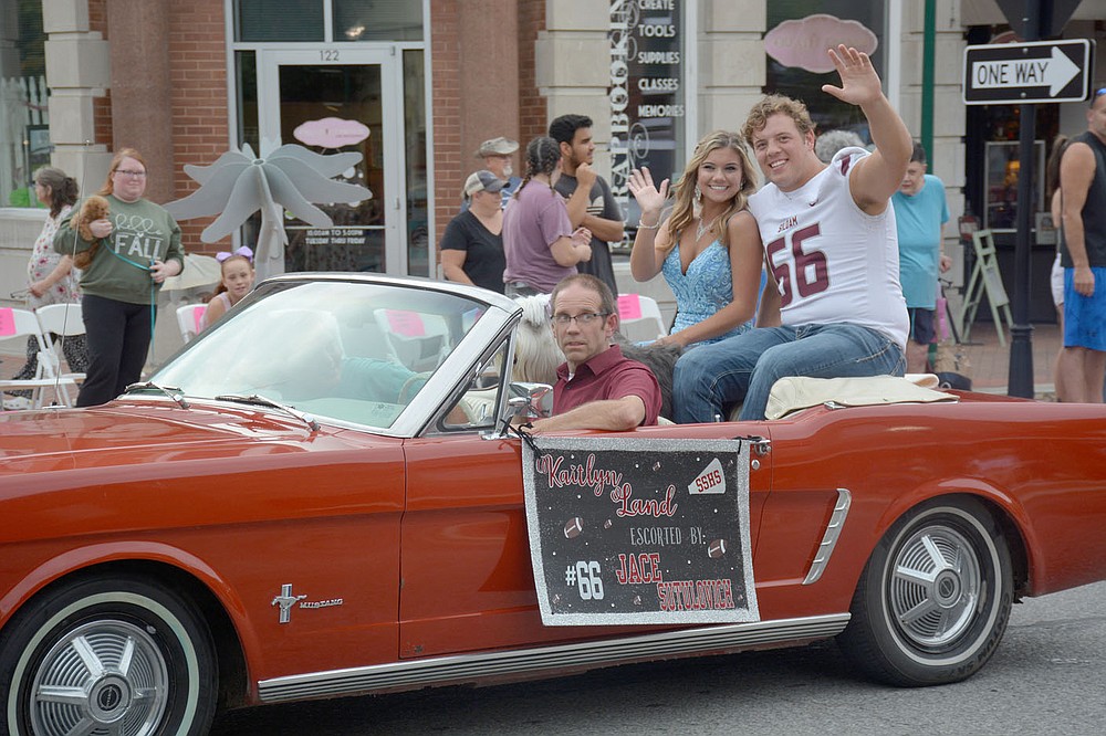 Graham Thomas / Siloam Sunday Kaitlyn Land and Jace Sutulovich wave to the crowd at the Siloam Springs reunion parade on Wednesday in downtown Siloam Springs.