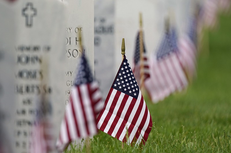 FILE - In this May 31, 2021 file photo, flags and tributes mark the Memorial Day holiday at Fort Logan National Cemetery in southeast Denver. The number of U.S. military suicides jumped by 15% last year, fueled by significant increases in the Army and Marine Corps that senior leaders called troubling. They urged more effort to reverse the trend. (AP Photo/David Zalubowski)