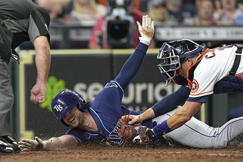Tampa Bay Rays' Brett Phillips, left, is tagged out at home plate by Houston Astros catcher Jason Castro while trying to stretch a triple into a home run during the eighth inning of a baseball game Wednesday, Sept. 29, 2021, in Houston. (AP Photo/David J. Phillip)