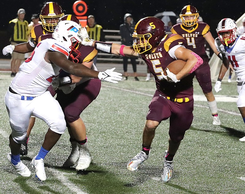 Lake Hamilton's Justin Crutchmer (5) runs for a gain as Little Rock Parkview's Benjamin Allen (26) defends Friday at Wolf Stadium. Lake Hamilton’s Justin Crutchmer (5) runs for a gain as Little Rock Parkview’s Benjamin Allen (26) defends Friday at Wolf Stadium. The Wolves took a 24-14 win over the Patriots to move to 5-0 and take the sole lead of the 6A-West. - Photo by Richard Rasmussen of The Sentinel-Record