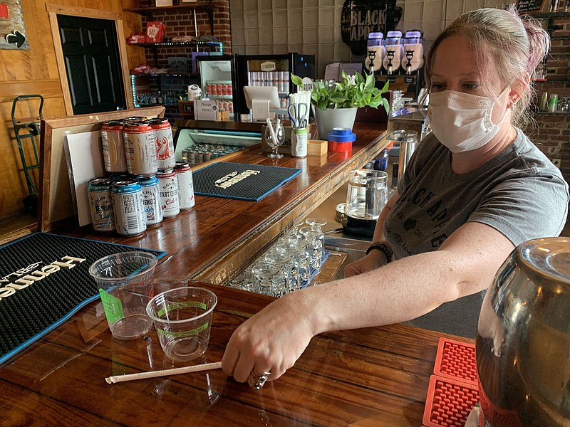 Alicia Beilby, tap room assistant at Black Apple, shows the compostable straws and drink containers Friday, Sept. 24, 2021, that are used by the business in Springdale. The Boston Mountain and Benton County solid waste districts are trying to gather more information from small businesses and offer them more ways to recycle. Go to nwaonline.com/211003Daily/ for today's photo gallery.
(NWA Democrat-Gazette/Andy Shupe)