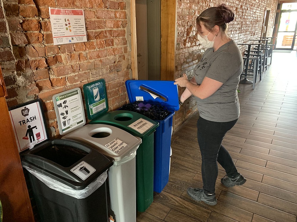 Alicia Beilby, tap room assistant at Black Apple, shows one of the business? recycling stations Friday, Sept. 24, 2021, that is available to its patrons at the business in Springdale. The Boston Mountain and Benton County solid waste districts are trying to gather more information from small businesses and offer them more ways to recycle. Go to nwaonline.com/211003Daily/ for today's photo gallery.
(NWA Democrat-Gazette/Andy Shupe)